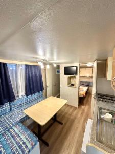 a caravan with a table and a bed in a room at Kamp Slanik Mobile Homes in Umag