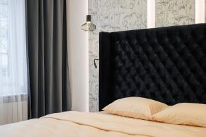 Luxury Apartments Laborca في أوجهورود: سرير مع اللوح الأمامي الأسود في غرفة النوم
