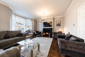 a living room with couches and a fireplace at Awel y Mor in Llandudno
