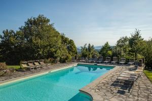 una piscina con sedie a sdraio e un resort di Villa Case a Cantuccio a San Giustino