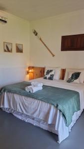- une chambre avec un grand lit et des serviettes dans l'établissement Pousada Manguezal, à Icaraí