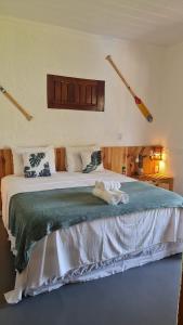 - une chambre avec un grand lit et une couverture verte dans l'établissement Pousada Manguezal, à Icaraí