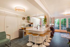 cocina con mesa y taburetes en una habitación en Chic Apartment South Paris • 90 m² up to 8 persons • Villa des Ammonites en Meudon