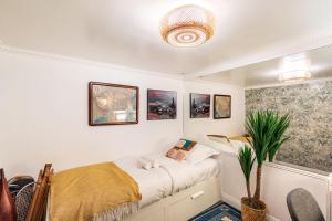 ein Schlafzimmer mit einem Bett und einer Topfpflanze in der Unterkunft Chic Apartment South Paris • 90 m² up to 8 persons • Villa des Ammonites in Meudon