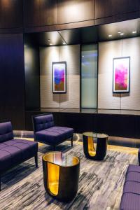 een wachtkamer met banken, tafels en schilderijen bij InterContinental Toronto Centre, an IHG Hotel in Toronto