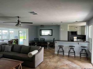 a living room with a couch and a kitchen at Gulf Access Canal Home! in Cape Coral