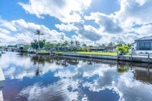 a body of water with buildings and palm trees at Gulf Access Canal Home! in Cape Coral