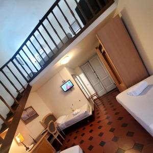 Habitación con cama y escalera con TV. en Hotel Fedora, en Florencia
