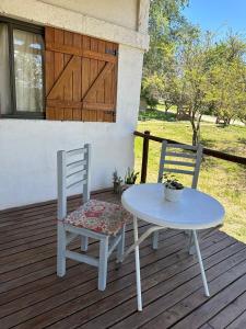 a table and two chairs sitting on a deck at Cabañas del Amanecer in Tanti