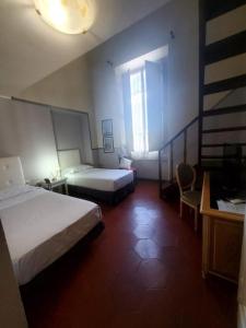 フィレンツェにあるホテル フェドラのベッド2台と窓が備わるホテルルームです。
