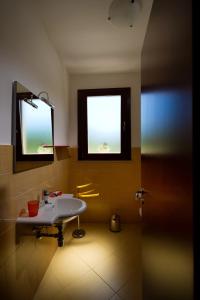 Un baño con lavabo y ventana. en Al Cantuccio, en Castelluzzo