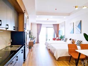 a hotel room with a bed and a kitchen and a kitchen at CĂN HỘ TMS LUXURY RESIDENCES 28 NGUYỄN HUỆ QUY NHƠN in Quy Nhon