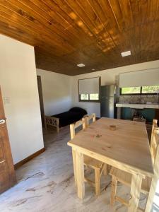 comedor con mesa de madera y sofá en Casa a estrenar 450 metros de la playa en Quequén