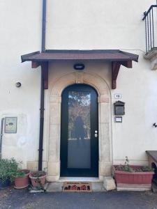 una puerta delantera de un edificio con una puerta negra en Bengiorne! Casa vacanza Al Viale en Raiano