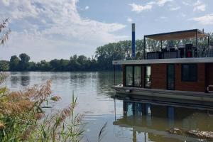 un barco está atracado en un cuerpo de agua en Riverboat-Rhein-Main Ferienloft, en Wiesbaden