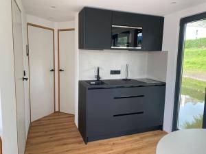 a kitchen with a black counter and a sink at Hausboot-Wiesbaden-Riverboat-Rhein-Main Ferienloft in Wiesbaden