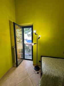 gelbes Zimmer mit einer Tür zu einem Balkon in der Unterkunft Bengiorne! Casa vacanza Al Viale in Raiano
