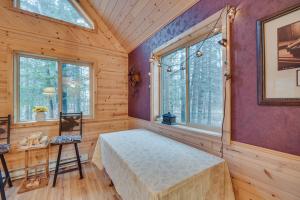 Habitación con cama, mesa y ventanas. en Barnum Cabin on 30 Acres with Soo Line Trail Access!, 