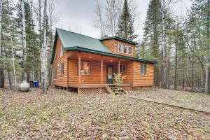 una cabaña en el bosque con techo verde en Barnum Cabin on 30 Acres with Soo Line Trail Access!, 