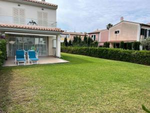 een tuin met twee blauwe stoelen en een huis bij Villa Dulce in Port d'Alcudia +23 foto's