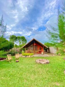 uma casa com um jardim de relva com um edifício em Quinta dos Laranjais Chalés em Viçosa do Ceará