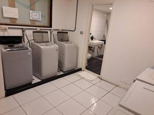 baño con 3 lavadoras y lavamanos en Taichung saint hotel en Taichung