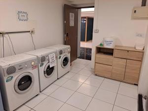 een wasruimte met 2 wasmachines en een aanrecht bij Taichung saint hotel in Taichung