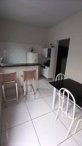 a kitchen with a table and two chairs and a refrigerator at Stúdio Cozy in Palmas