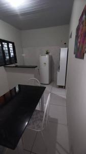 a kitchen with a black table and a refrigerator at Stúdio Cozy in Palmas