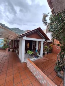 a house with a brick patio and a house at HERMOSA Y COMODA CASA FAMILIAR EN Baños in Baños