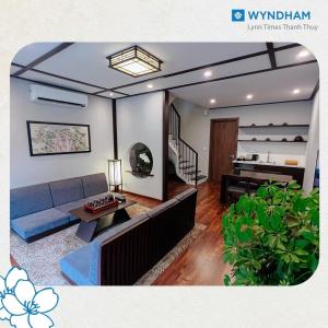 uma sala de estar com um sofá e uma mesa em Wyndham Thanh Thuỷ em Phú Thọ