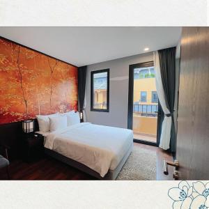 una camera da letto con un grande letto bianco e una finestra di Wyndham Thanh Thuỷ a Phú Thọ