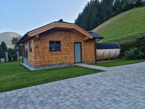 a small building with a large pipe next to a hill at Ferienwohnung Unterdürmoos in Annaberg im Lammertal +20 photos