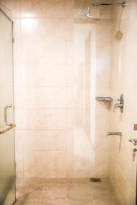 bagno con doccia e porta in vetro di Shared room in three bedrooms, private bathroom, gym, office area, kitchen, Wonderiss Home Westland Living a Nairobi