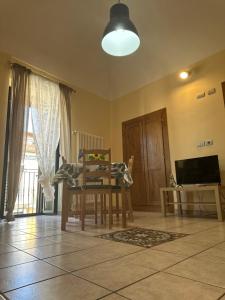 een woonkamer met een tafel, een stoel en een televisie bij Bengiorne! Casa Ginestra in Raiano