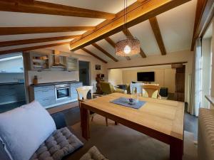 a living room with a dining table and a kitchen at Kaiser's Landhaus in Schliersee