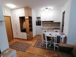 cocina con armarios blancos y mesa blanca en Milnik apartman, en Zlatibor
