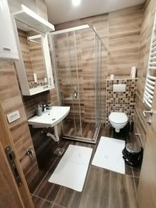 y baño con ducha, aseo y lavamanos. en Milnik apartman, en Zlatibor