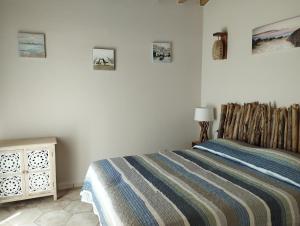 een slaapkamer met een bed met een gestreepte deken bij Col di Pietra in Giuncarico