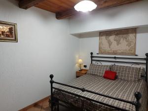 1 dormitorio con cama negra y almohada roja en La Taverna Alloggio ad uso turistico - VDA -Sarre - CIR- 0073, en Aosta