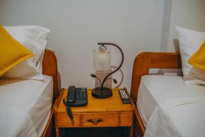une chambre avec deux lits et une lampe sur une table de chevet dans l'établissement Hotel Cielo Tarapoto, à Tarapoto