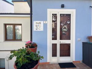 a blue building with a door and potted plants at B&b Niu Susu in Lanusei