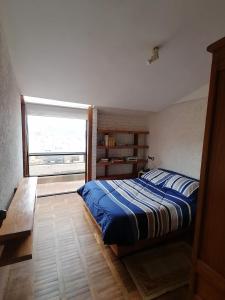 a bedroom with a bed and a large window at Villa Florita in La Paz