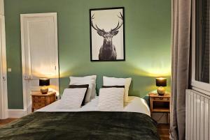 - une chambre dotée d'un lit avec une photo de cerf sur le mur dans l'établissement Appartement tout équipé - Centre-ville EPERNAY, à Épernay