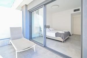 - une chambre avec un lit, une chaise et une fenêtre dans l'établissement Glamorous 3BR Penthouse near Rothschild Boulevard, à Tel Aviv