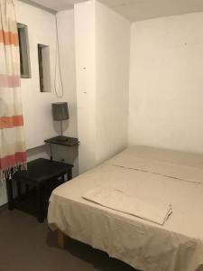 um quarto com uma cama e uma mesa com um candeeiro em Minidepa em Lima