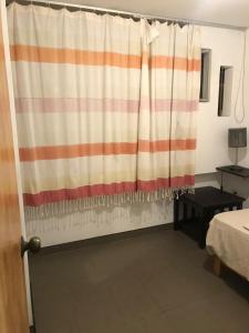 um quarto com uma cortina listrada num quarto em Minidepa em Lima