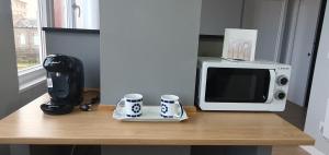 Un mostrador con dos tazas de café y un microondas en Pisos uso turistico Torno-Cubelas-Caosa Buenavista en San Ciprián