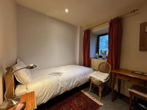 a bedroom with a bed and a desk and a window at High Trenhouse in Settle