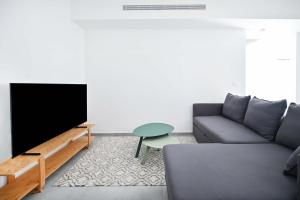 un soggiorno con divano e TV a schermo piatto di Glamorous 3BR Penthouse near Rothschild Boulevard a Tel Aviv